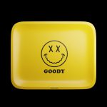 The Goody Glass Yellow Big Face Rolling Tray is pictured from above, showing a square yellow tray with a smiling face graphic.