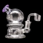 Clear glass dab rig with a spherical chamber and quartz banger, isolated on a black background.