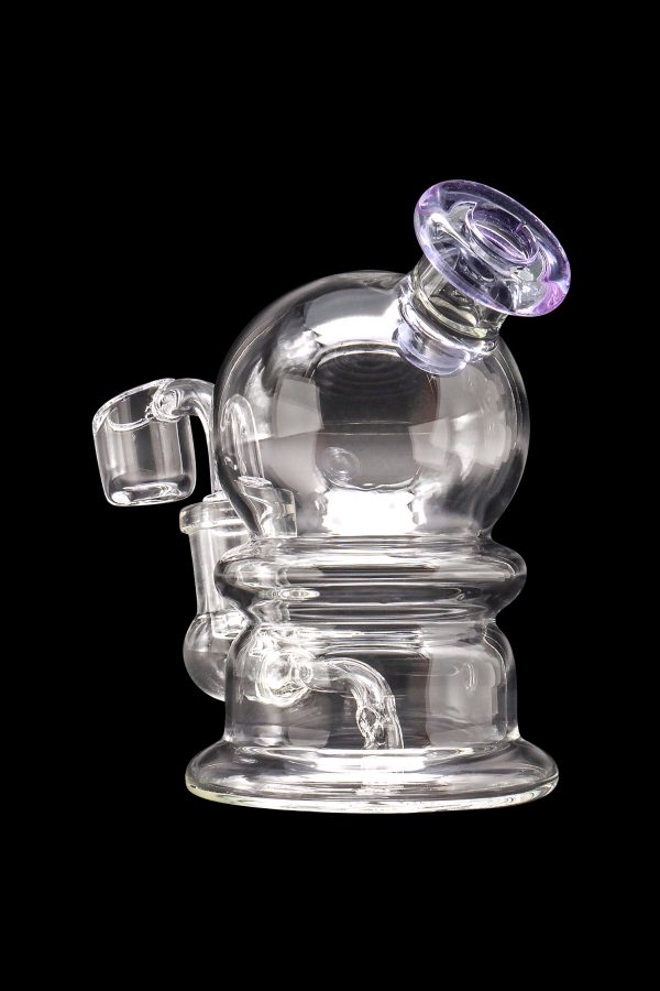 Clear glass dab rig with quartz banger, isolated on a black background.