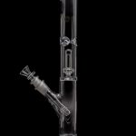 Clear glass water pipe (bong) with ice catcher and downstem, isolated on black.