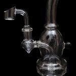 Clear glass dab rig with a quartz banger, isolated on a black background.