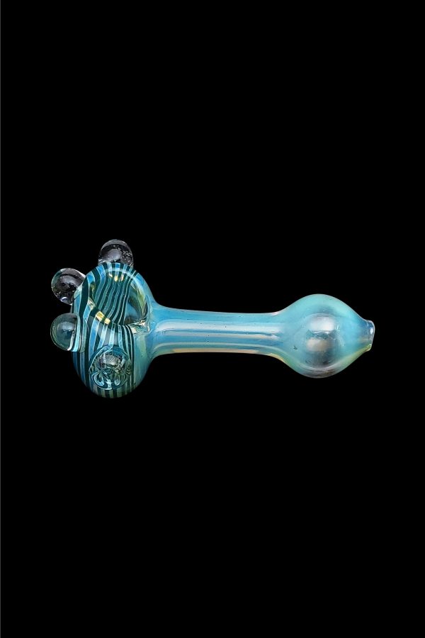 Blue glass pipe with swirling green and white accents, isolated on a black background.