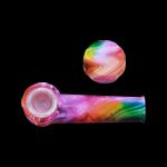 Colorful silicone cannabis pipe and cap against a black background.