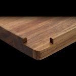 Wooden rolling tray with slots for rolling papers, isolated on black.