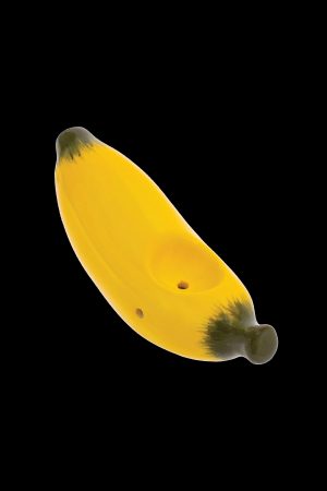 Yellow glass banana-shaped pipe with visible holes, isolated on a black background.