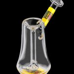 A three-quarter view of the K. Haring Glass Bubbler, showcasing the clear glass construction and colorful artwork.