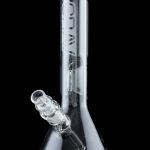 Clear glass bong with a flared base and downstem, reflecting on a black surface.