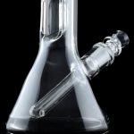 Clear glass water pipe (bong) with ice catcher, reflected on a black surface.