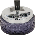 A close-up, angled view of the Glass Spinning Ashtray with a clear glass base and silver spinning cover.