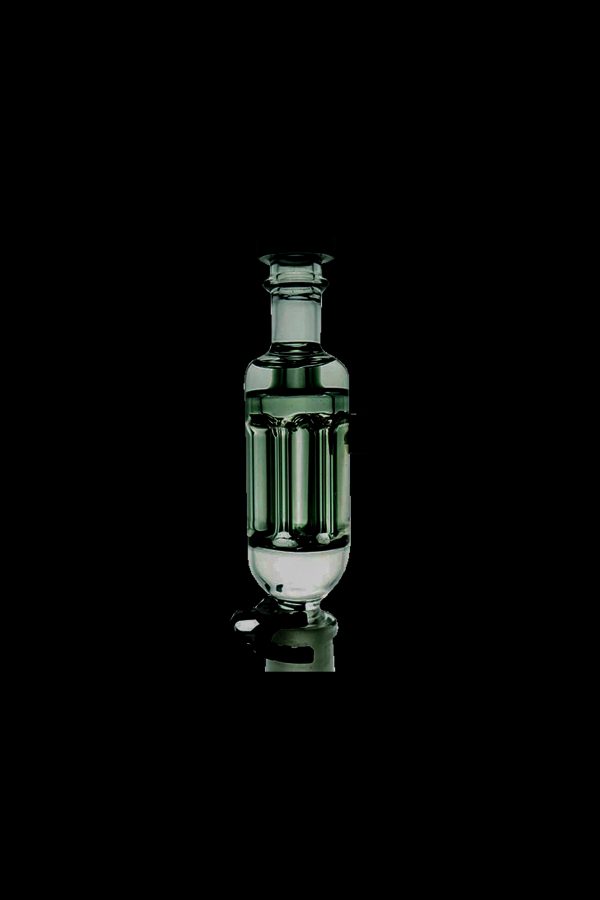 Green glass bubbler for cannabis smoking, isolated on a black background.