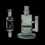 Glass bubbler and water pipe with intricate designs, isolated on a black background.