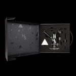 Open black gift box displaying cannabis smoking accessories, including a glass pipe, vaporizer, and tools, with a geometric pattern and "Hs" logo.