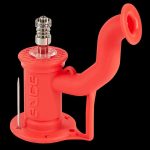 Red silicone oil rig with a quartz banger and dab tool.
