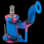 Blue and pink silicone dab rig with a quartz banger and carb cap, isolated on a black background.