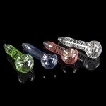 Assortment of colorful glass smoking pipes on a reflective black surface.