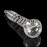 Clear glass pipe with white spiral detailing, reflecting on a black surface.