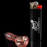 Red glass bubbler pipe and black lighter with "Smoke Cartel" branding on a reflective surface.