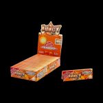 A close-up of the branded packaging for Juicy Jay's 1 1/4 Peaches and Cream Rolling Papers, displaying vibrant peach and cream colors.