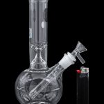 Glass water pipe (bong) and lighter on a black background.