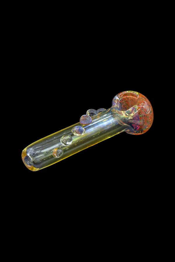 Glass cannabis pipe with iridescent bubbles and a speckled bowl, isolated on black.