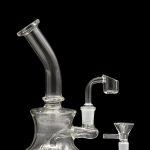 Clear glass water pipe (rig) with a quartz banger and ceramic insert, studio shot on black.