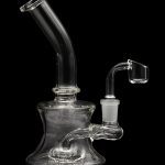 Clear glass dab rig with a quartz banger, isolated on a black background.