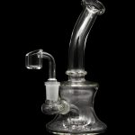 Clear glass dab rig with a quartz banger, isolated on a black background.