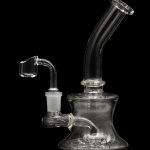 Clear glass dab rig with a quartz banger, isolated on a black background.
