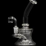 Clear glass dab rig with a quartz banger, isolated on a black background.