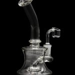 Clear glass dab rig with a quartz banger, isolated on a black background.