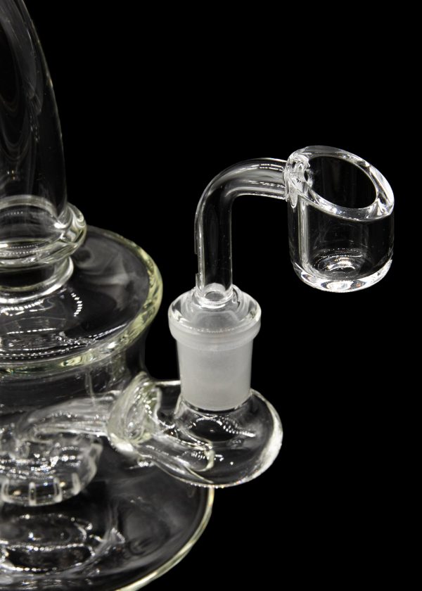 Clear glass dab rig with a quartz banger against a black background.