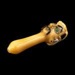 Glass pipe with a monster-themed design, isolated on a black background.