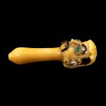Yellow glass pipe with sculpted skull details.