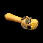 Hand-blown glass cannabis pipe sculpted as a monster head with exposed teeth and glowing green eyes.