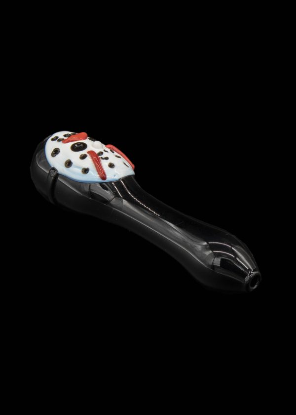 Black glass pipe shaped like a ladybug with red and white detailing, isolated on a black background.