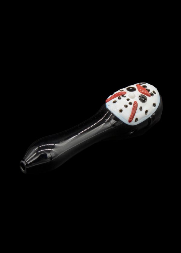 Glass pipe shaped like a ladybug with black and white spotted head and shiny black stem, isolated on a black background.