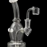 Clear glass dab rig with a quartz banger, isolated on a black background.