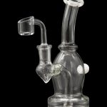 Clear glass dab rig with a quartz banger, illuminated against a black background.