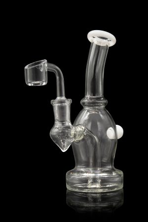 Clear glass dab rig with a quartz banger, illuminated against a black background.