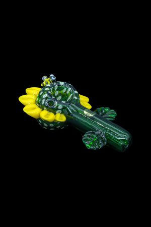 Hand-blown glass cannabis pipe shaped like a frog with yellow bubble details, isolated on a black background.