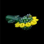 Hand-blown glass frog with yellow floral accents, likely a cannabis smoking piece.