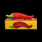 Red chili pepper-shaped smoking pipe and its packaging on a black background.