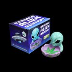 Ceramic alien ashtray with packaging, featuring a UFO and marijuana leaf design.