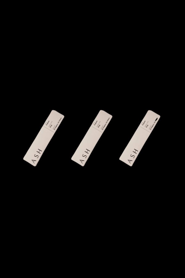 Three minimalist, rectangular cannabis pre-roll packs labeled "ASH" against a black background.