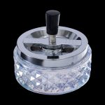 Crystal ashtray with a metallic rotating lid, designed for cannabis use.