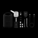 Auxe cannabis vaporizer kit laid out on a black surface, including the device, glass chamber, charging cable, and various accessories.