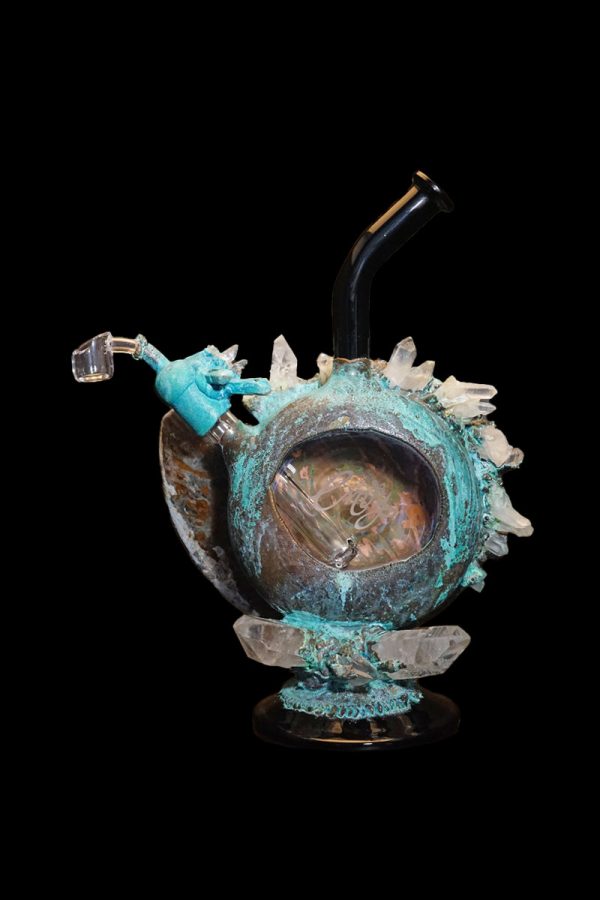 A detailed glass water pipe shaped like a pumpkin, adorned with crystal-like spikes and a turquoise-blue glaze, set against a black background.