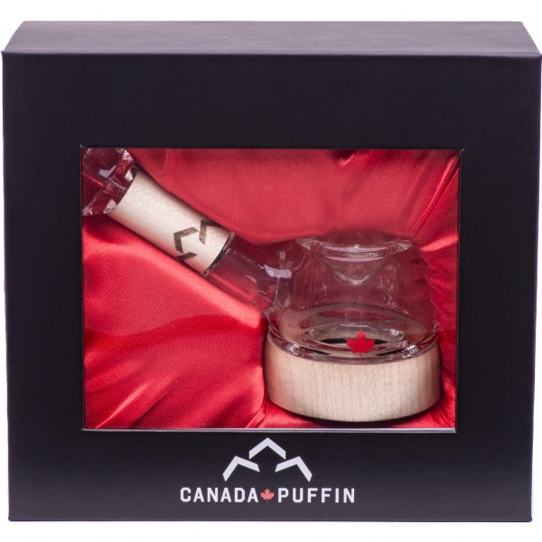 Front view of the Canada Puffin Stone Spoon Pipe resting on a reflective surface, highlighting its compact, curved design.