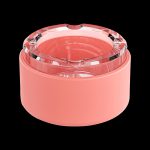 Coral-colored cannabis grinder with clear acrylic top.