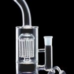 Clear glass water pipe (bong) with a percolator and accompanying glass downstem, isolated on a black background.